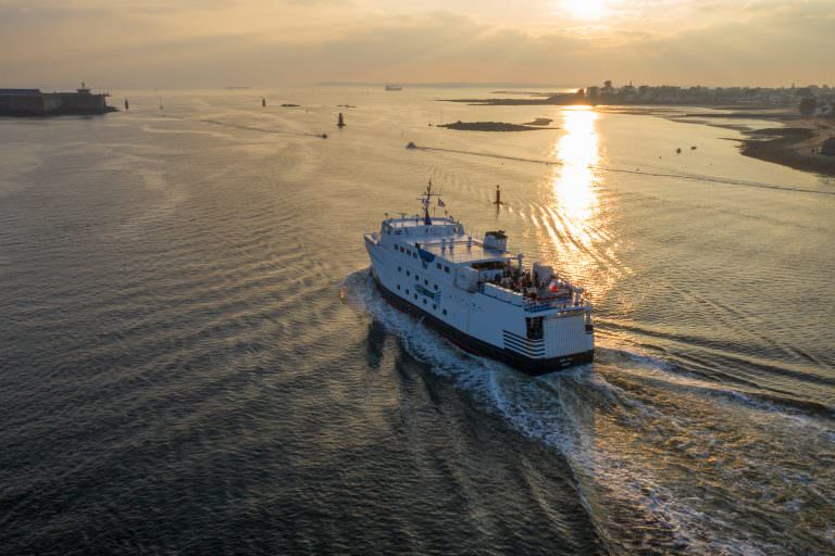 Vue aérienne du bateau de Groix sortant de la rade de Lorient au soleil couchant