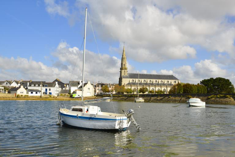 Voilier devant l'église Sainte Radegonde à Riantec, depuis la Petite Mer de Gâvres (Morbihan)