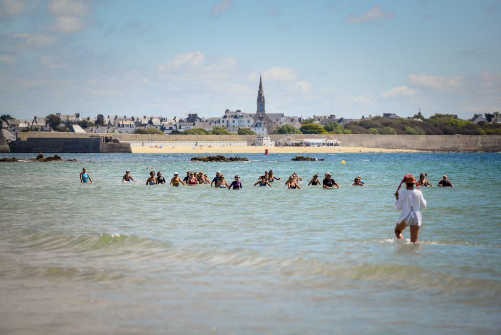 Larmor-Plage, marche aquatique en groupe sur la plage de Toulhars et plage de Port-Louis au loin.