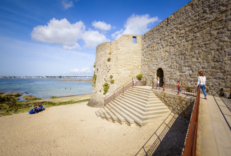 Passage du sentier cotier de la plage du Lohic à Port-Louis au pied des remparts