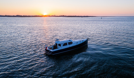 La vedette Key Largo en traversée au large de l'île de Groix au coucher de soleil (Morbihan)