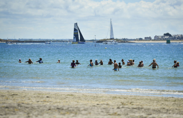 Larmor-Plage, marche aquatique en groupe sur la plage de Toulhars et voiliers au loin.