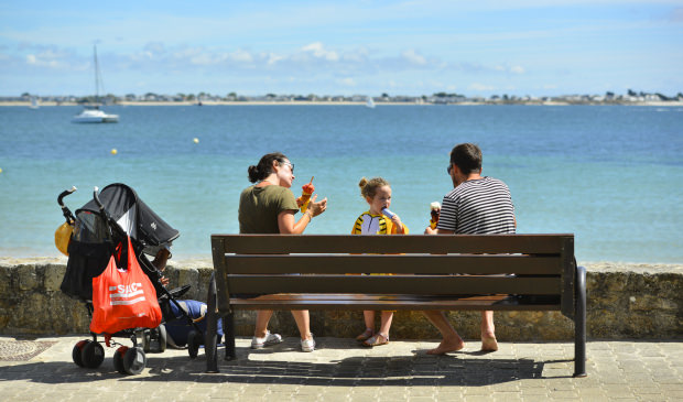 En famille assis sur un banc, se poser et déguster une glace sur la promenade de Port-Maria à Larmor-Plage