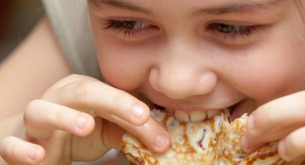 enfant qui mange une crêpe