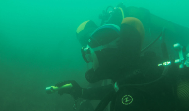 Plongeurs sous l'eau, éclairant une épave, documents visibles au musée sous-marin de Lorient La Base (Morbihan)