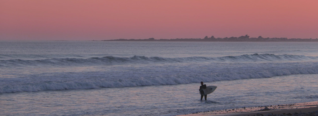surfeur au coucher du soleil à Linès